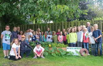 Die Schülerinnen und Schüler der Astrid-Lindgren-Schule präsentierten Klimaschutzmanager Ludger Frese stolz ihre Gemüseernte und freuten sich riesig über das Geschenk. © Stadt Meppen